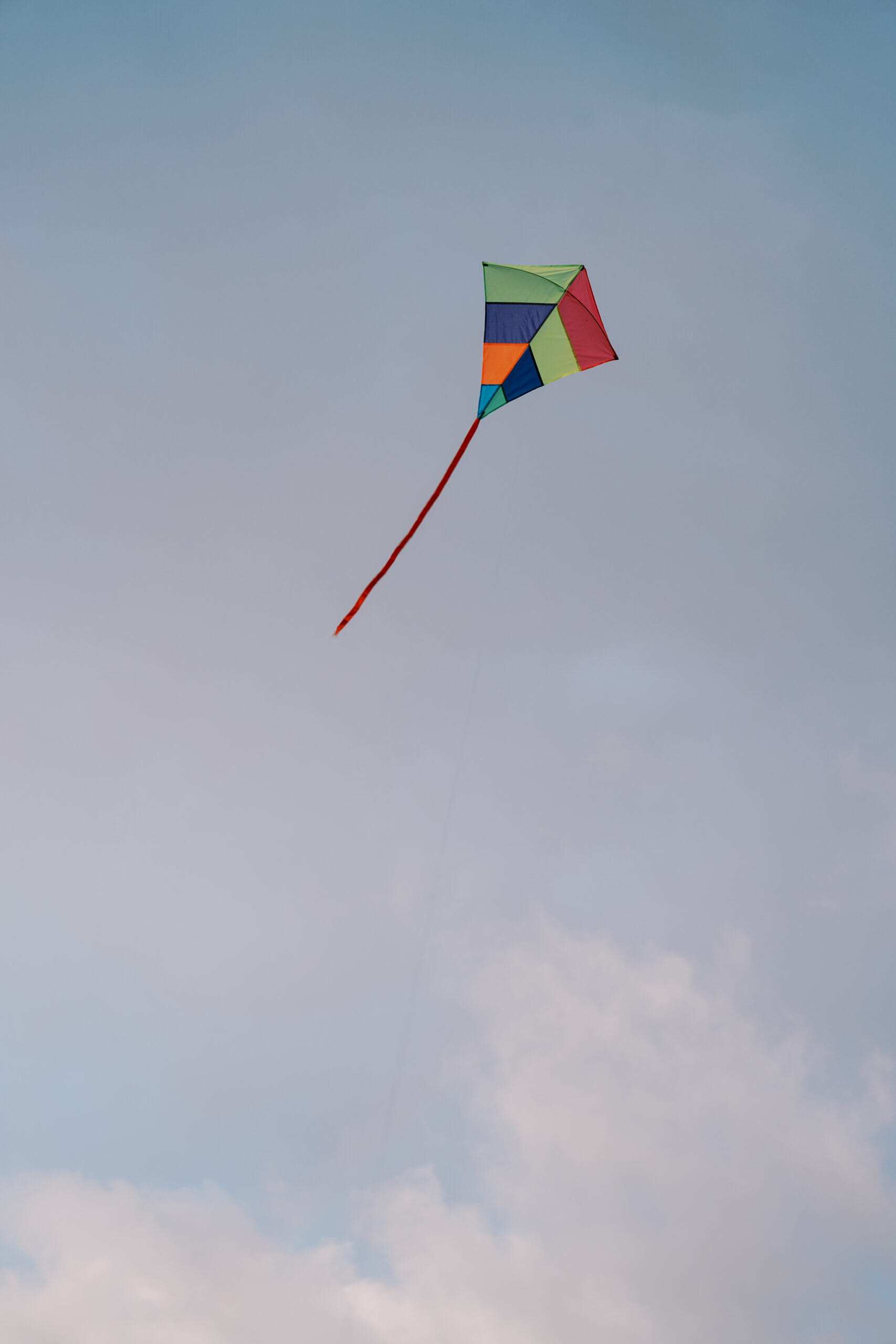 Rainbow kite soars in the cloudy sky